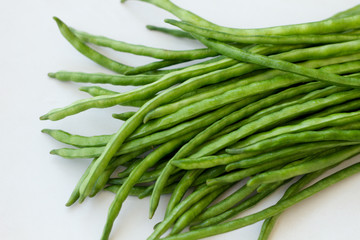 Fototapeta premium Bunch of green beans lying on a light table