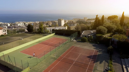 People playing tennis on luxury court, hobby and relax, private sports club