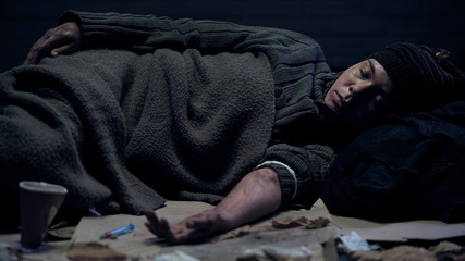 Drug abused homeless person lying street after taking dose, narcotic addiction