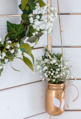 Spring decor. Easter decor. Photozone. A wreath of leaves on a wooden white background. Vase with flowers