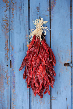 Traditional red chile ristra on rustic blue door.