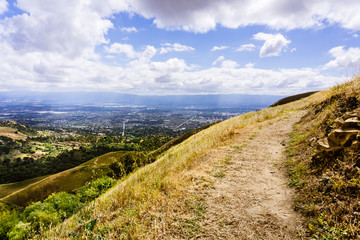 Fototapeta na wymiar Hiking trail through the hills of south San Francisco bay area, San Jose visible in the background, California