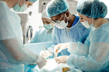 talented doctors performing reconstructive surgery after illness or trauma in the operating room