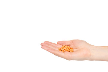 Hand with orange pills, medical care and help, chemical vitamins.