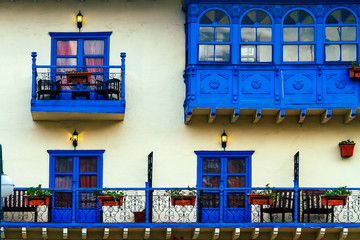 Blue balconies with plants and flowers in a colonial building in Cusco, Peru