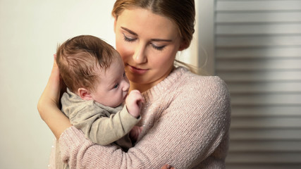 Babysitter holding little adorable newborn in orphanage, adoption in new family