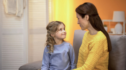 Fototapeta premium Little girl and mother looking at each other and smiling, special connection