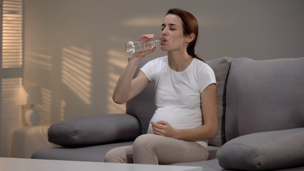 Pregnant alcohol addicted female suffering withdrawal symptoms drinking vodka