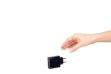 Hand with black USB wall chrger plug, three ports.