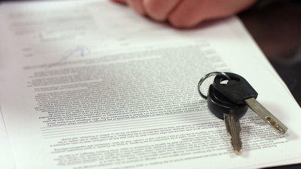 Car keys on contract page closeup, transportation rent agreement, legal deal