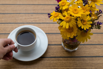 a cup of coffee with flowers on the table in the balcony. enjoy holiday time at the hotel or house