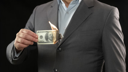 Businessman burning one hundred dollar bill, financial crisis bankruptcy concept