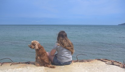 girl with a dog watching the sea