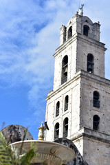 Fototapeta na wymiar Lion's Fountain (foreground) and Convento San Francisco de Asis at Plaza de San Francisco, Havana old town, Cuba