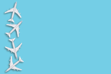 flat lay traveling conceptual with airplane. Transportation concept. colorful background. Many white air plane on blue background in left side, space for text.