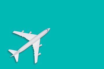Flat lay travel concept design with plane on tiffany background with copy space. White blank model of a passenger plane