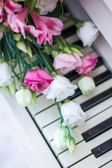 Bouquet of flowers. Flower Arrangement: Roses, Eustomas, Alstroemeria on the Piano