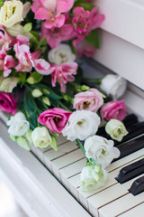 Bouquet of flowers. Flower Arrangement: Roses, Eustomas, Alstroemeria on the Piano
