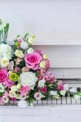Bouquet of flowers. Flower Arrangement: Roses, Eustomas, Alstroemeria on the Piano