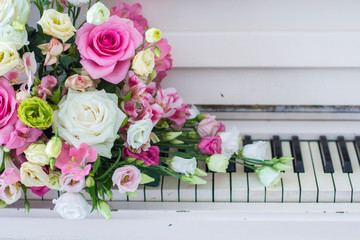 Bouquet of flowers. Flower Arrangement: Roses, Eustomas, Alstroemeria on the Piano