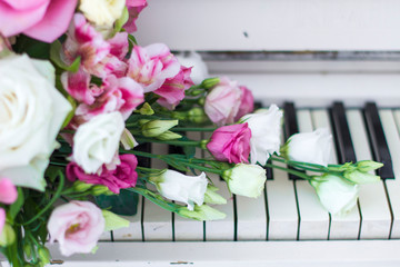 Bouquet of flowers. Flower Arrangement: Roses, Eustomas, Alstroemeria on the Piano