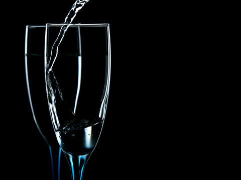 Elegant picture in glasses is poured with clean water on a black background