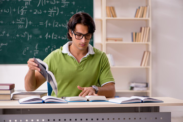 Handsome student in front of chalkboard with formulas 