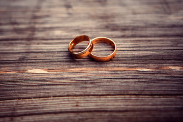 wedding rings. jewelery in white and yellow gold. Wedding ring on the wooden texture. wooden stub