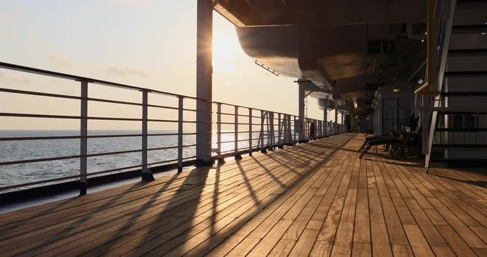 Cruise ship deck Pacific ocean sunrise over water. Beautiful Caribbean Ocean from cruise ship vacation. Smooth sea water. Sunrise or sunset rays and shadows on deck. Travel.