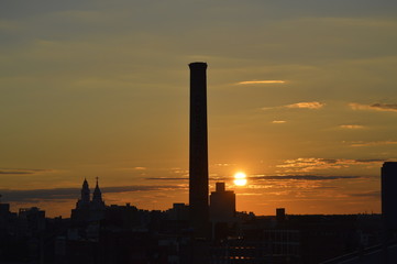 Sunset over Philadelphia with factory chimney and a church outline