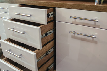 Wooden furniture with drawers and glossy white MDF facades