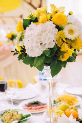 wedding bouquet with white carnations and ranunculi. delicate bouquet in yellow and white. eucalyptus leaves.