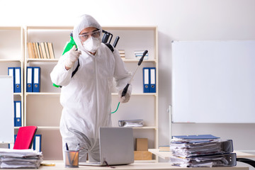 Professional contractor doing pest control at office 