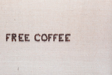 Free coffee words made of coffee beans on linen canvas, arranged middle left