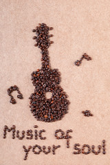 Guitar and inscription made of coffee beans on plywood surface