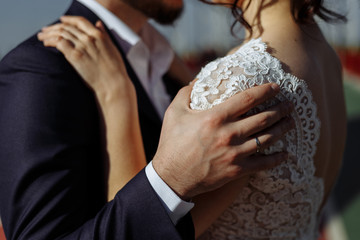 Caucasian happy romantic young couple of groom and bride walks on bridge above river