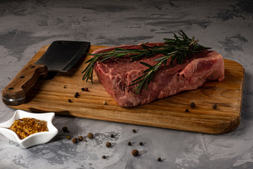 A piece of fresh marbled beef on a cutting board, ready to cook.