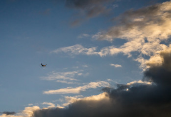 Fototapeta premium Passenger jet airplane on the background of the cloudy sky. Spring evening, overcast. Airplanes take off from the airport nearby.