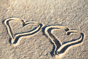 Fototapeta na wymiar Two Hand Drawn Heart On Sand At Beach