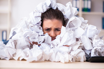 Businesswoman rejecting new ideas with lots of papers