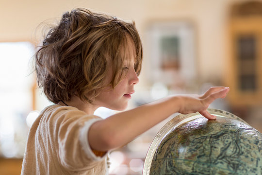 5 year old boy touching globe