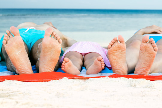 Family Lying On Blanket At Beach