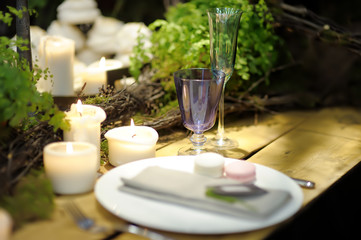 Table set for an event party or wedding reception in rustic or scandinavian style decorated moss and fern. Fashionable table set.