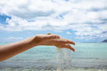 Fototapeta na wymiar Sand Falling Through Her Hands On The Beach