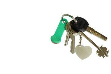 A bunch of 5 keys and a keychain in the form of a heart. Keys on a white background isolated.