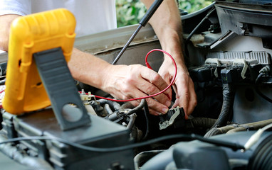 Auto technician troubleshooting electrical problems in car/truck engine