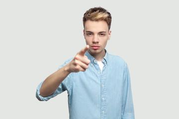 Hey you. Portrait of serious bossy handsome young man in light blue shirt standing, accusing and...