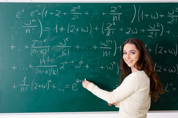 Young female math teacher in front of chalkboard  