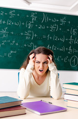 Young female math teacher in front of chalkboard  