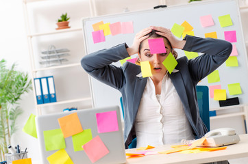 Young female employee in conflicting priorities concept 